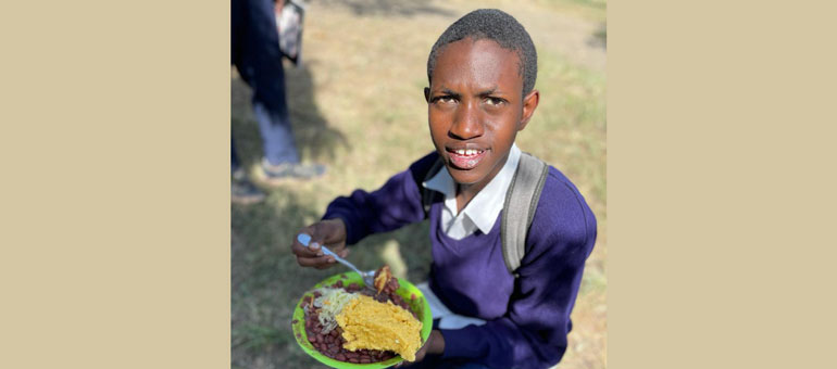 A boy eating a biofortified school meal in Tanzania