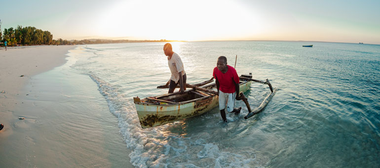 Two men with a boat on the beach
