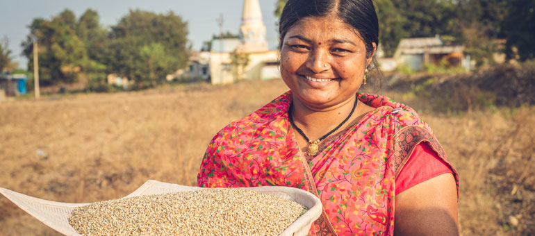 Smiling woman holding ground millet
