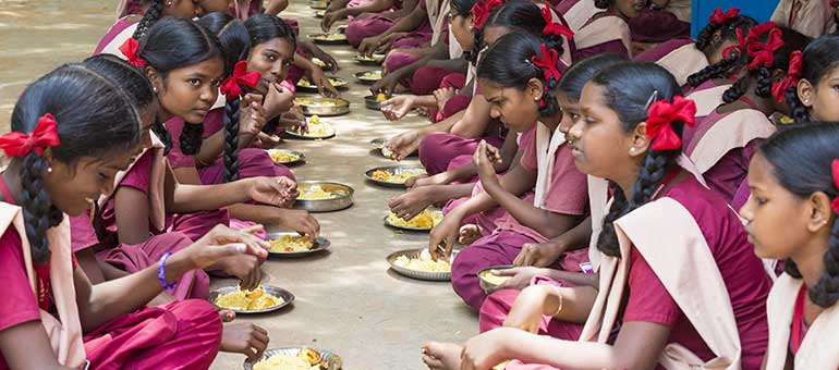 Girls eating in a school in India