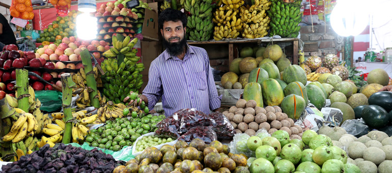 Man selling vegetables in a market in Bangladesh