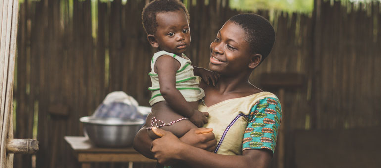 rwanda-woman-holding-baby-and-smiling