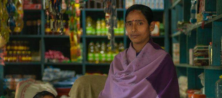 Woman looking at the camera and standing in front of her shop