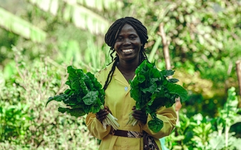 a woman holding some leafy greens