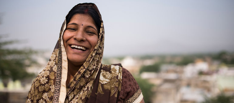 A woman in India smiling wearing a veil
