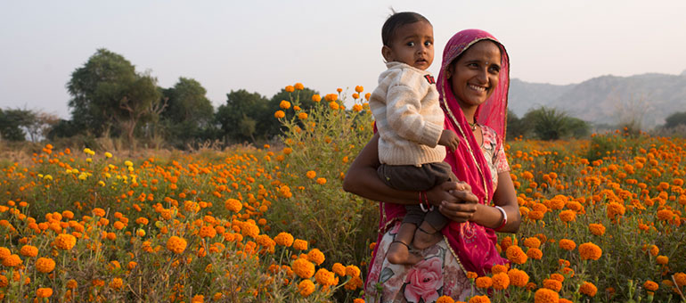 Mother with child in a dandelion field in India