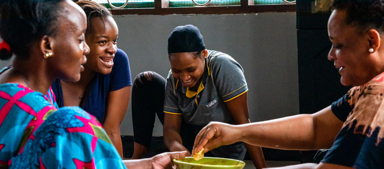 Women sharing food and smiling