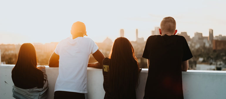 Young people looking from a balcony down to new york