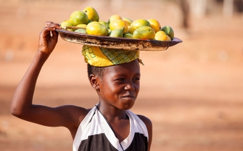 A child carrying fruits in Africa