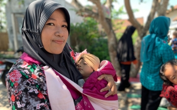 Mother holding a sleeping baby in Indonesia