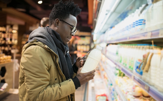 African man checking food labels in supermarket