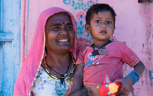 A woman in a pink veil holding her child