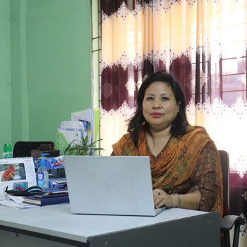 Daina sitting at her desk in front of her laptop